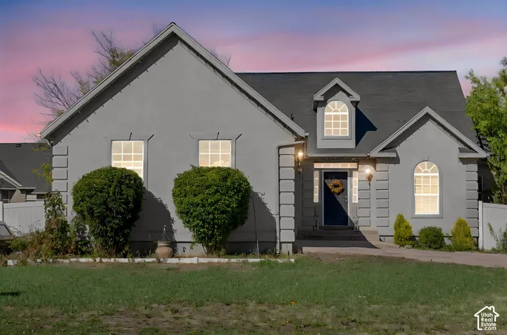 Stucco exterior featuring quoined corners, arched windows, decorative gables, and a dormer