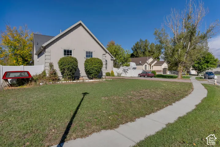 Single-story residence featuring a stucco exterior, quoin detailing, gabled roofline, and corner lot placement