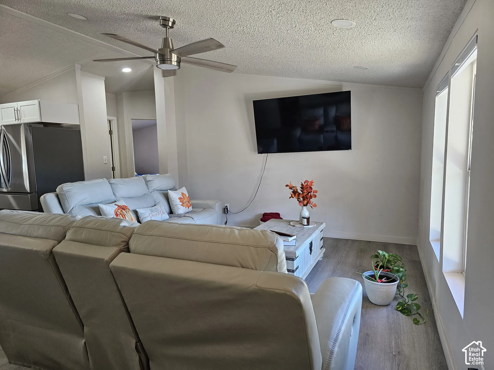 Vaulted ceilings, brushed-nickel ceiling fan, recessed lighting, and wood-finish flooring