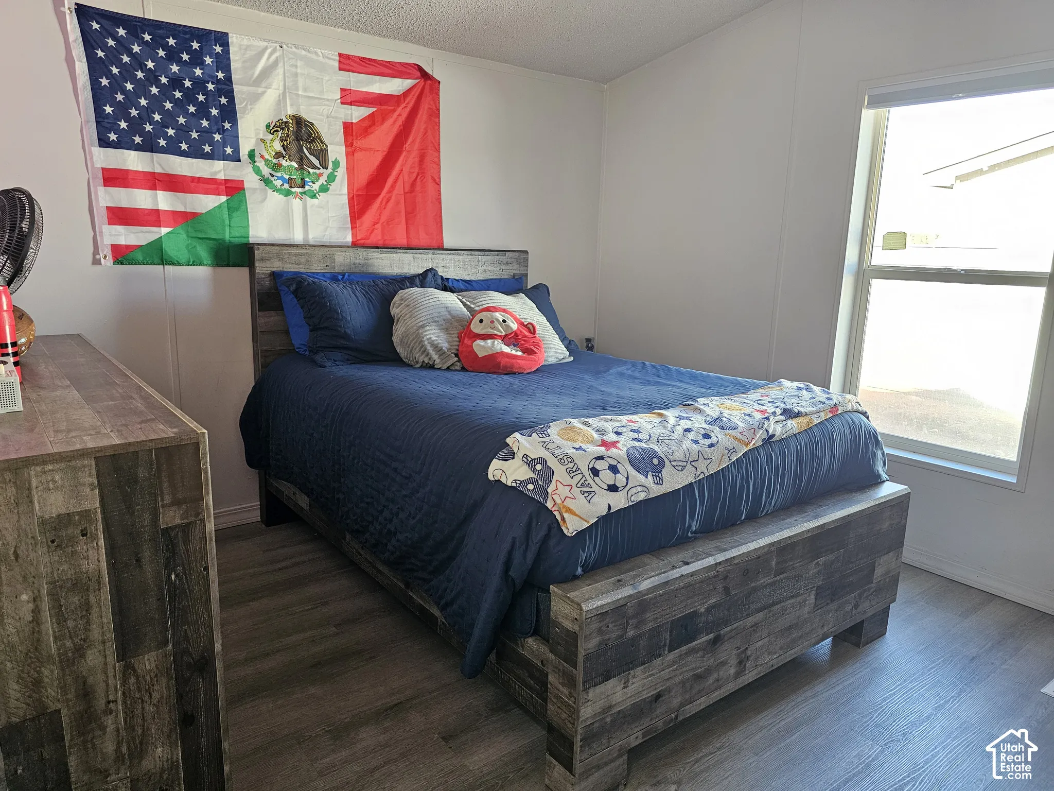 Neutral-toned wall finishes, wood-finish flooring, and a large dual-pane window