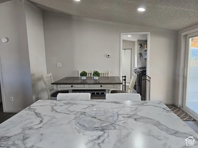 Stone-patterned island countertop, recessed ceiling lighting, and sliding glass door