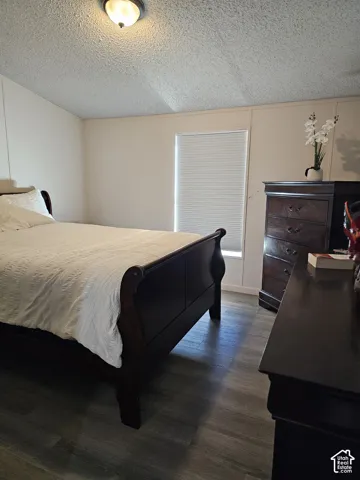 Wood-finish flooring, neutral-toned wall paneling, and an inset window with a pleated shade