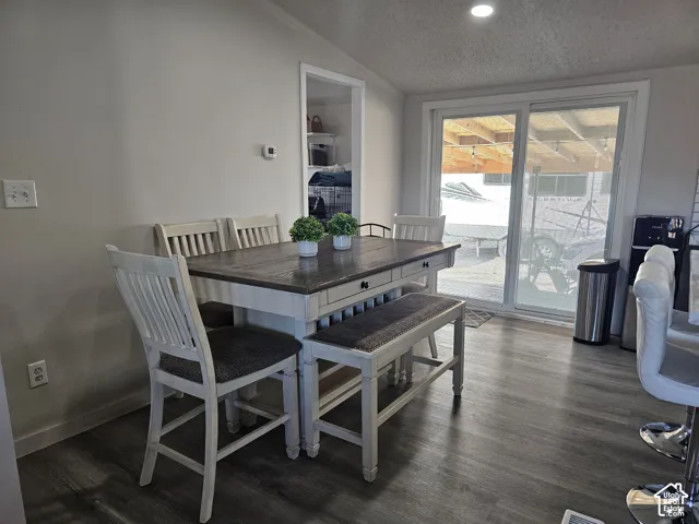 Neutral-toned interior featuring wood-finish flooring, recessed lighting, and a sliding glass door providing exterior access