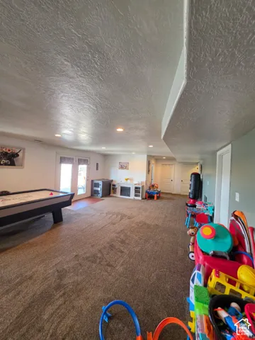 Spacious interior featuring recessed lighting, textured ceilings, wall-to-wall carpeting, and double glass doors with transom windows