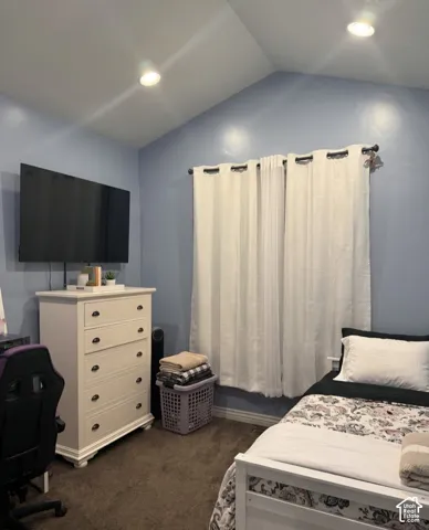 Vaulted ceilings, neutral carpeting, and recessed lighting