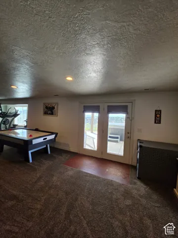 Interior space featuring wall-to-wall carpeting, recessed ceiling lighting, and double-glass doors with integrated blinds