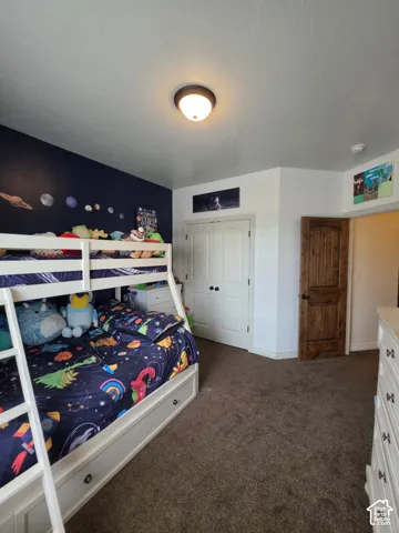 Room featuring an accent wall, dual-door closet, wood-finish interior door with an arched top, and ceiling-mounted dome lighting