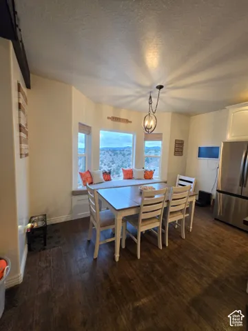 Dining area featuring wood-finish flooring, a built-in window seat, large multi-pane windows with mountain scenery, and a metal orb pendant light fixture
