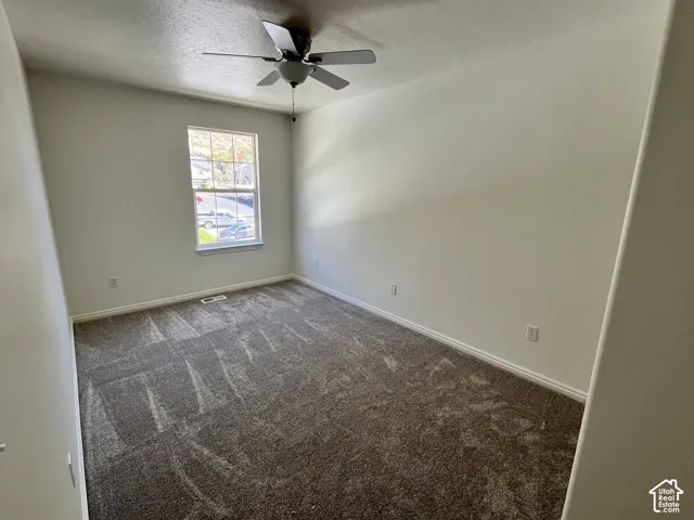Room featuring neutral wall tones, wall-to-wall carpeting, and a ceiling fan with integrated lighting