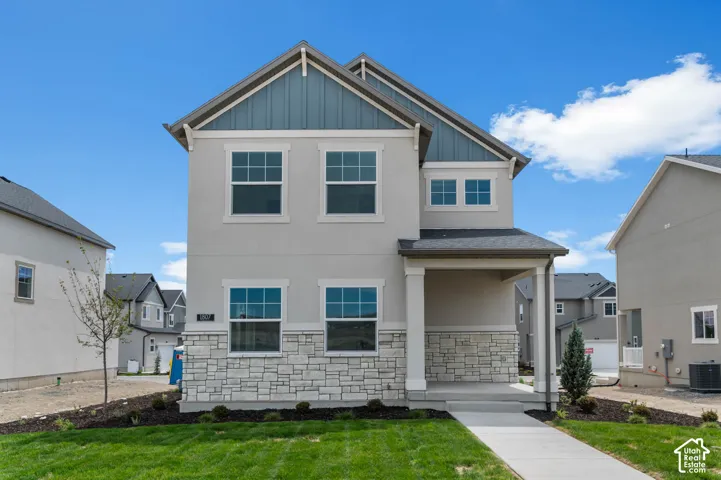 Two-story exterior featuring a neutral stucco facade, stacked stone veneer, vertical board-and-batten siding on the gable, and a covered front entry