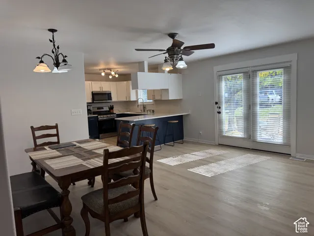 Kitchen featuring white upper cabinetry, navy base cabinets, and light-toned countertops