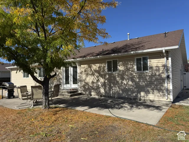 Exterior featuring horizontal siding, a concrete patio, double glass doors, and a gable roof with shingle finish