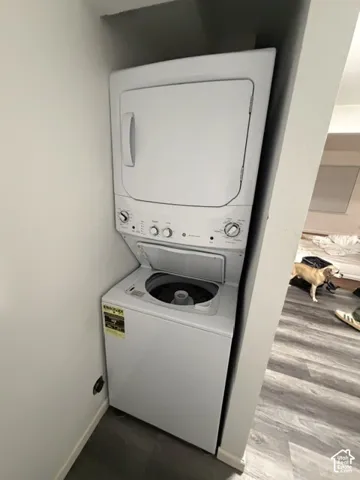 Stacked white laundry center featuring a top-load washer and front-load dryer unit