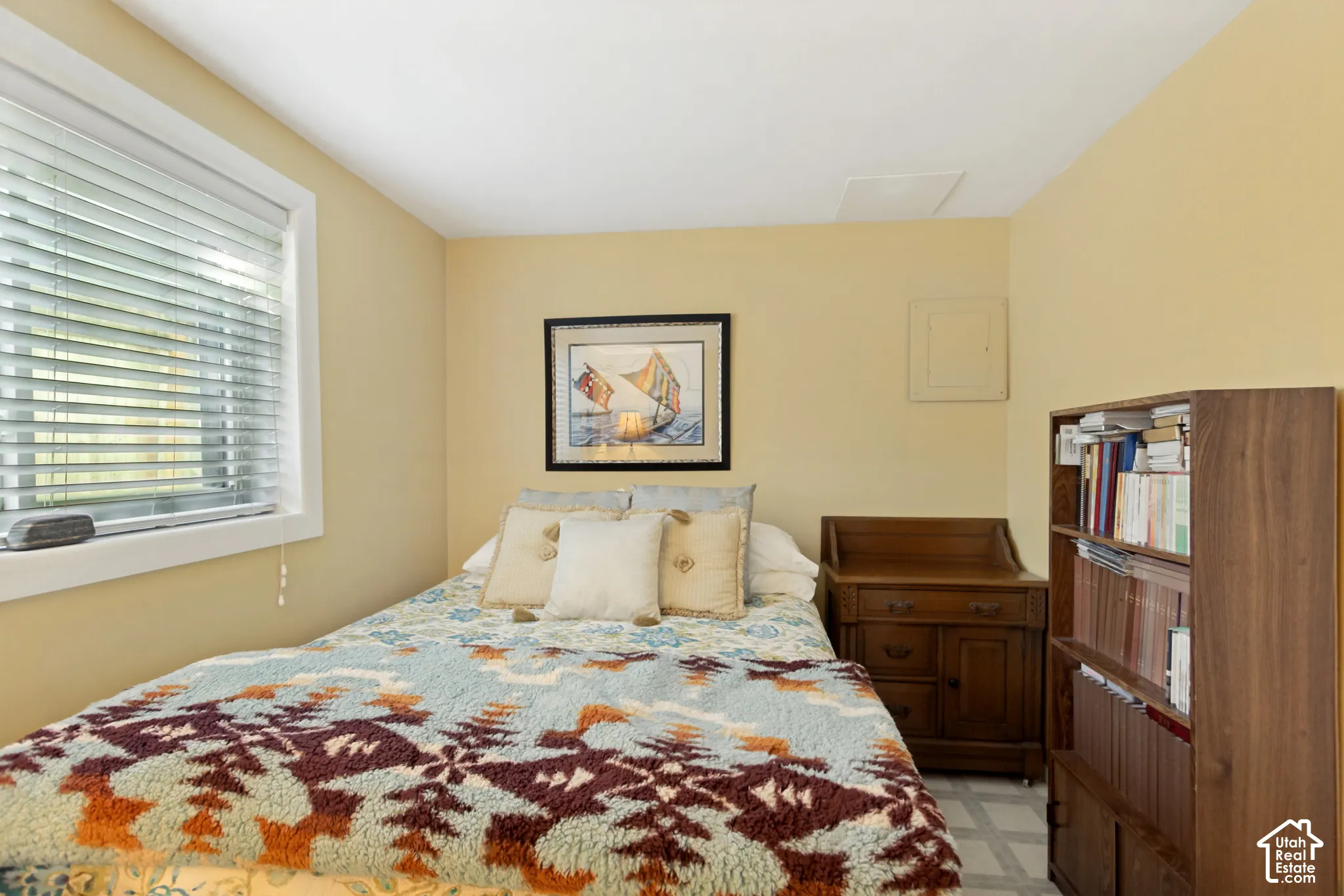 Neutral-toned walls featuring a horizontal window with adjustable slatted blinds and a ceiling-mounted access panel