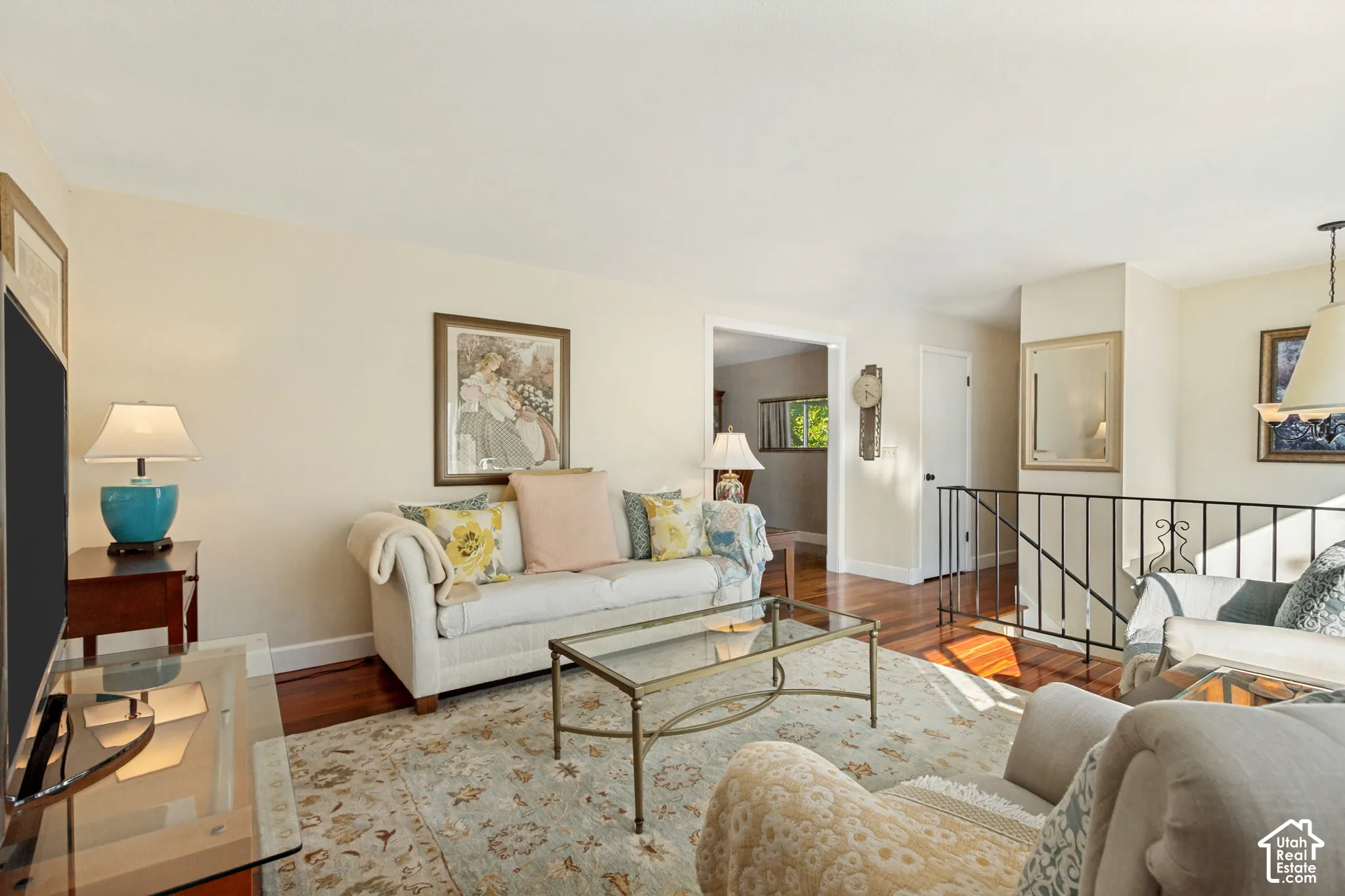 Wood-finish flooring, metal railing, and neutral wall tones