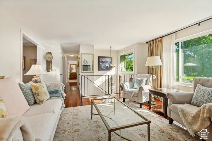Living area featuring wood-finish flooring, large picture windows, and decorative metal railings