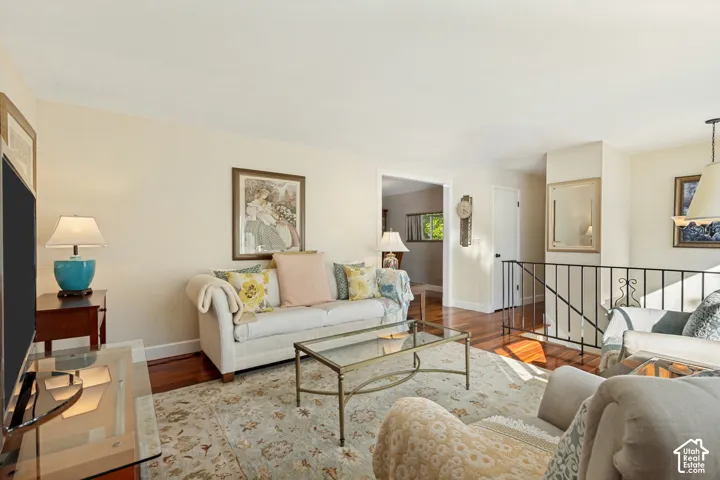 Wood-finish flooring, metal railing, and neutral wall tones