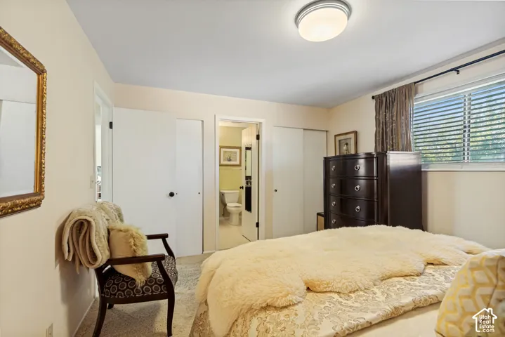 Interior room featuring neutral wall paint, flush-mount ceiling lighting, wall-to-wall carpeting, dual-door closet storage, and a window with horizontal blinds