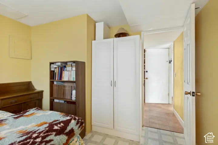 Interior space featuring yellow-toned wall paint, white six-panel door with metallic hardware, and patterned resilient flooring