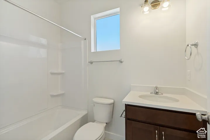 Bathroom featuring a white vanity with an integrated sink, a deep-tone wood cabinet, a combination bathtub and shower unit with built-in shelving, and dual-light wall sconce