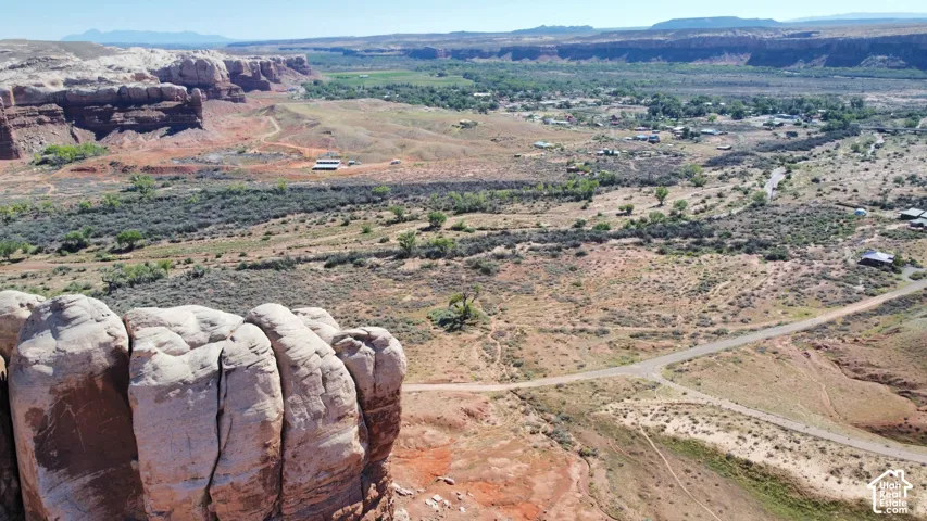 Expansive acreage featuring prominent sandstone rock formations, desert vegetation, and mountain terrain