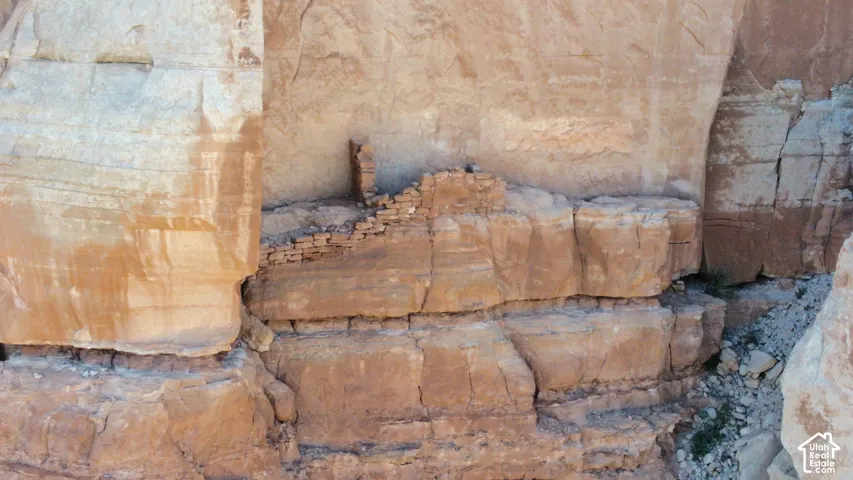 Natural sandstone cliffside formation featuring exposed rock faces and historic stone masonry structures