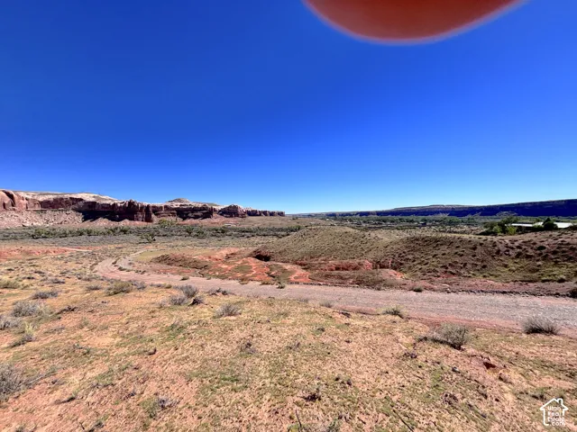 Expansive terrain featuring natural desert topography, rock formations, and native vegetation
