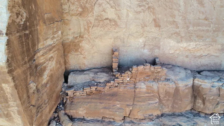Natural rock alcove featuring integrated masonry stone walls and terraced stone foundations