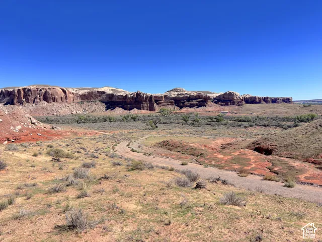 Expansive desert acreage featuring native shrubbery, natural dirt topography, and prominent red rock mountain formations
