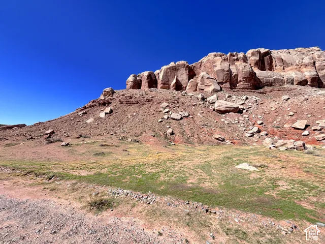 Natural sandstone rock formation featuring prominent red rock cliffs and native terrain