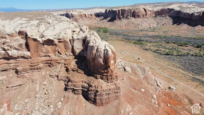 Expansive desert landscape featuring layered sandstone rock formations, rugged cliffs, and natural terrain