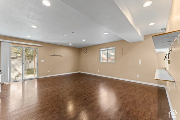 Interior space featuring wood-finish flooring, recessed lighting, a sliding glass door, and built-in wall shelving