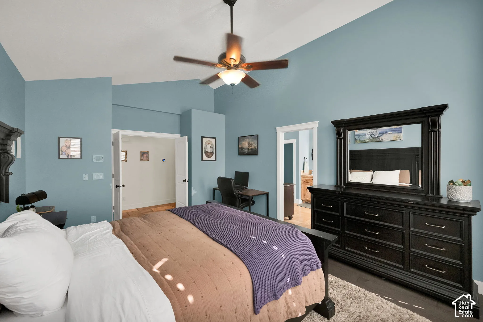 Vaulted ceiling featuring a central ceiling fan with integrated lighting