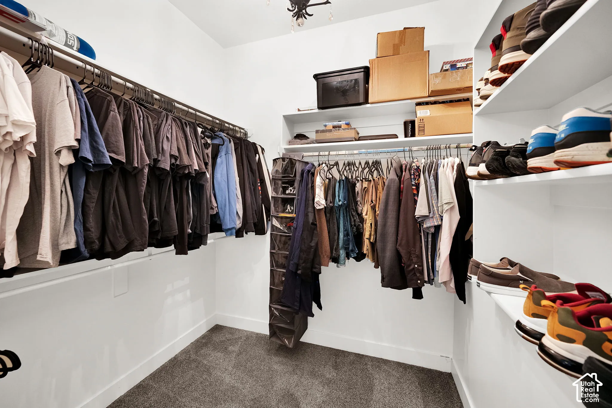 Walk-in closet featuring multi-level metal hanging rods and integrated white shelving