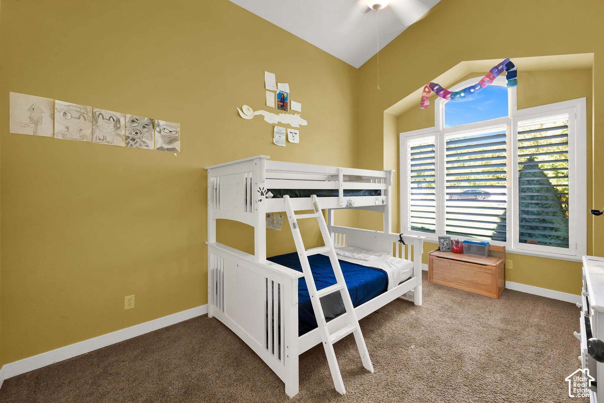 Vaulted ceilings, large multi-pane window with an arched transom, and neutral carpeting