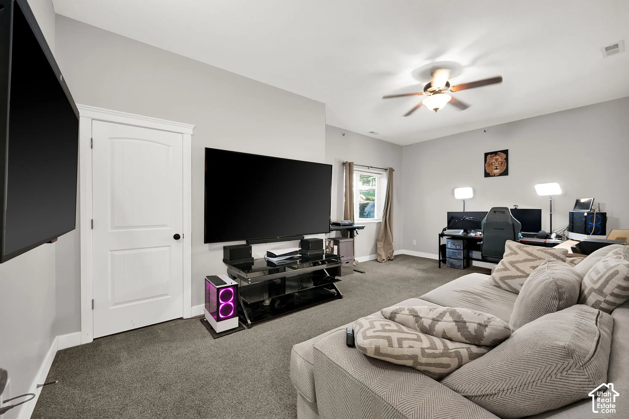 Room featuring neutral wall tones, wall-to-wall carpeting, a recessed window, and a multi-blade ceiling fan with an integrated light fixture