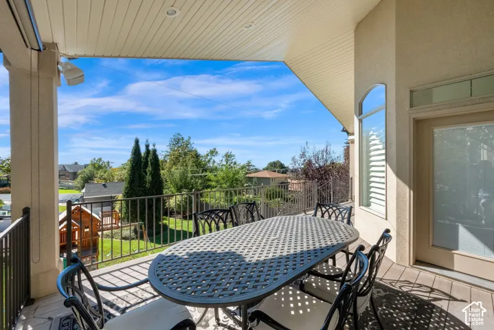 Covered patio featuring recessed lighting, metal railings, and wood-finish decking