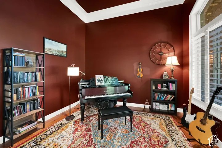 Interior room featuring hardwood flooring, crown molding, and plantation shutters