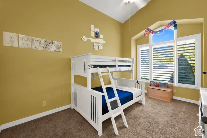 Vaulted ceilings, large multi-pane window with an arched transom, and neutral carpeting