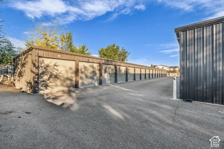 Multi-unit storage facility featuring metal siding, roll-up doors, and paved drive aisles