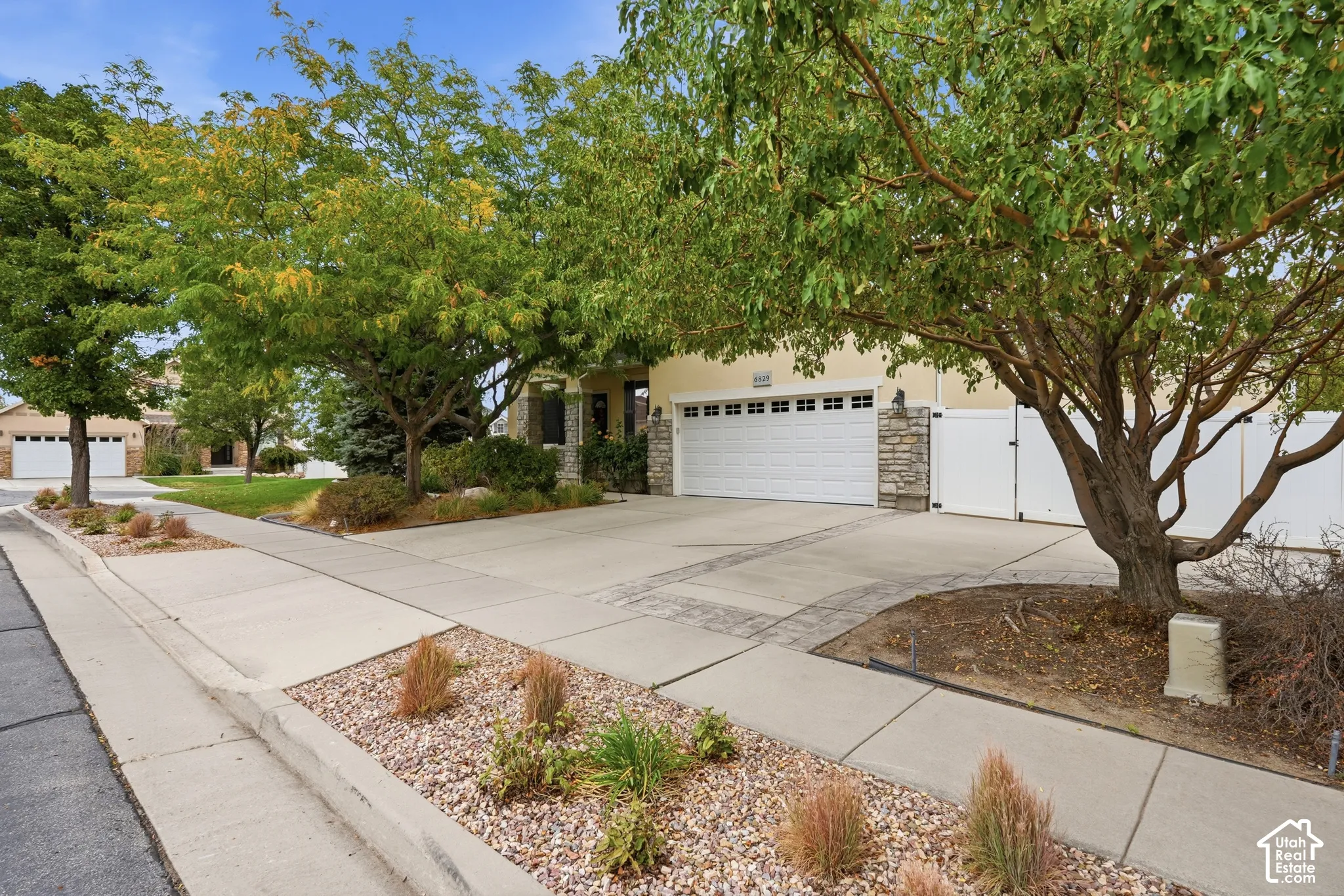 Exterior featuring a multi-car garage, stone facade accents, concrete driveway, and xeriscaped front grounds