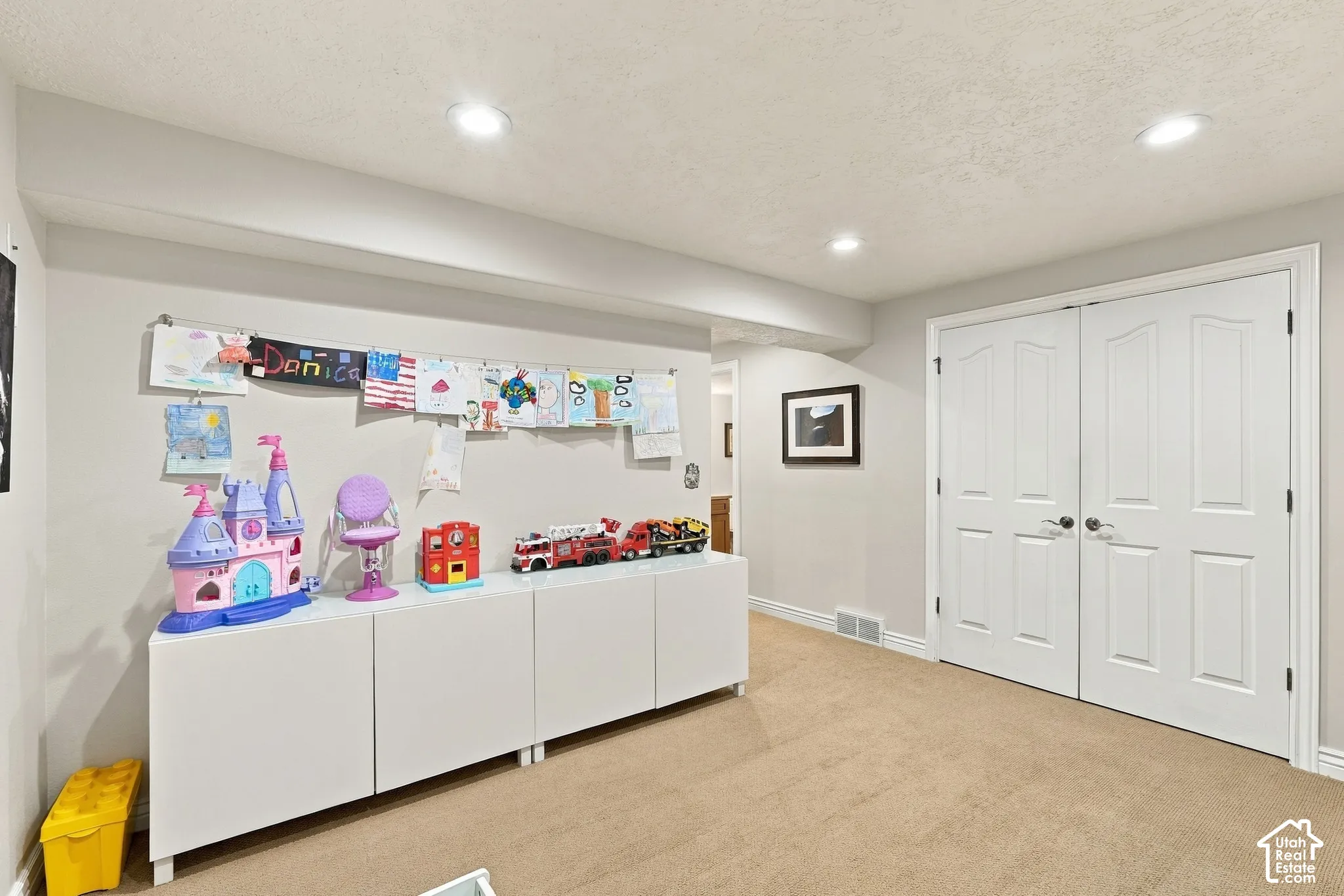 Interior space featuring neutral-toned carpeting, recessed lighting, and white double doors with brushed nickel hardware