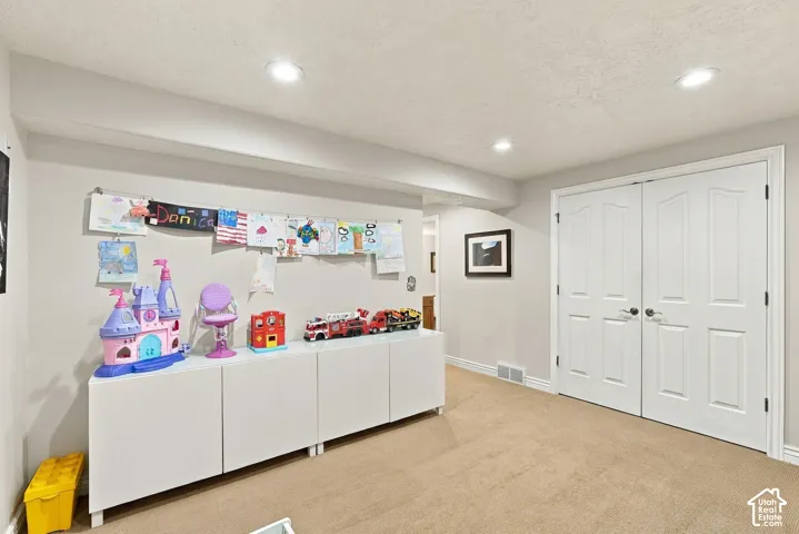 Interior space featuring neutral-toned carpeting, recessed lighting, and white double doors with brushed nickel hardware