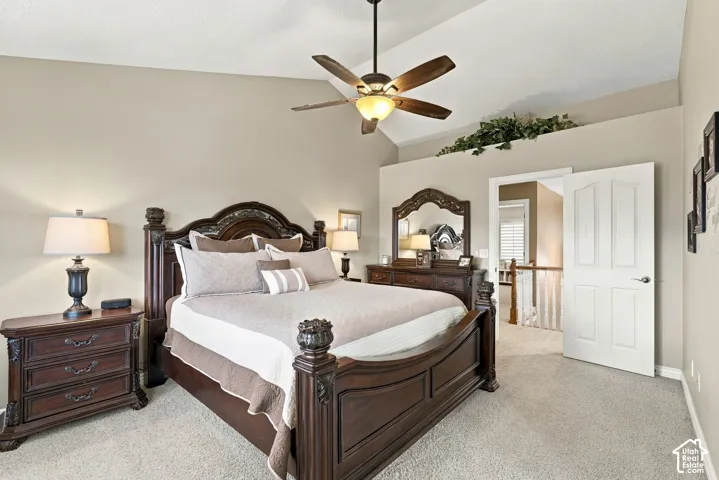 Vaulted ceilings, carpeted flooring, and a ceiling fan with integrated lighting