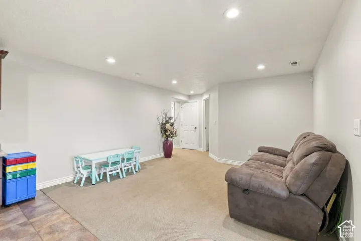 Neutral-toned interior space featuring recessed ceiling lighting, wall-to-wall carpeting, and multi-panel interior doors