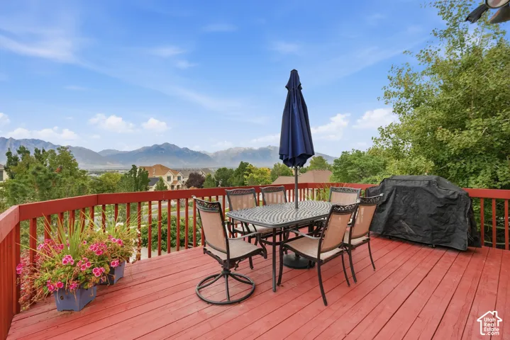 Elevated wooden deck featuring a perimeter railing and expansive mountain backdrop