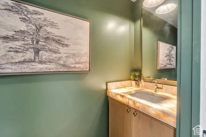 Built-in wood vanity with a backlit stone countertop, integrated sink, polished metal faucet, and arch-top mirror