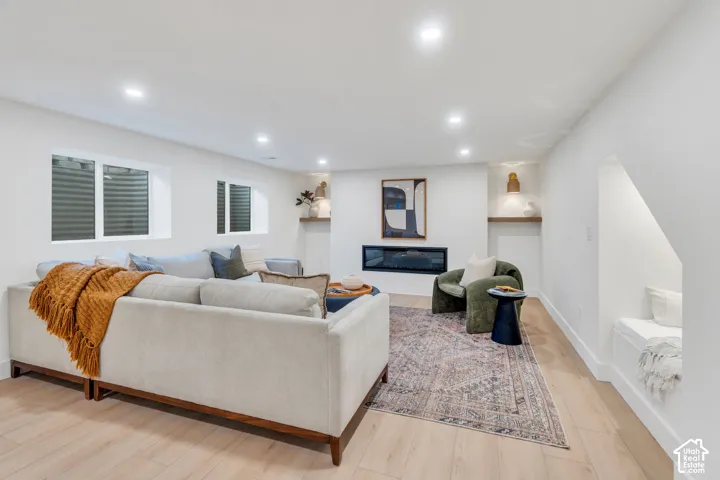 Recessed lighting, wood-finish flooring, built-in recessed shelving, integrated linear fireplace, and custom built-in bench seating