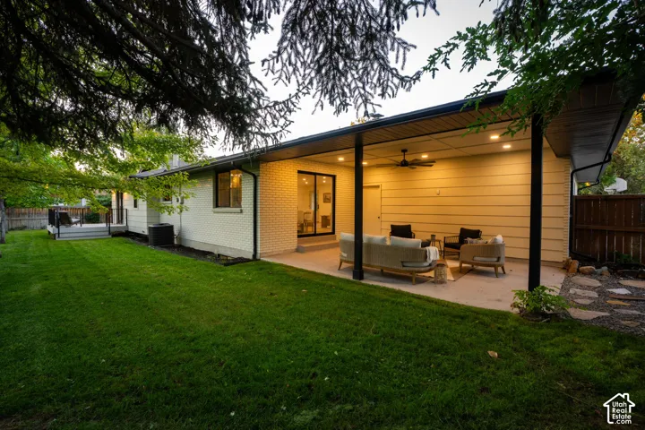 Covered concrete patio featuring recessed lighting, a ceiling fan, horizontal siding, brick exterior wall, and sliding glass doors