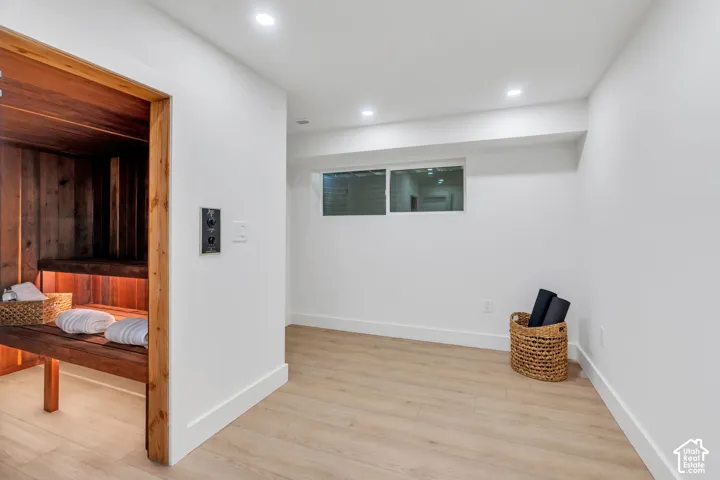 Sauna with natural wood interior, wood-finish flooring, recessed lighting, and horizontal slider window